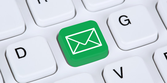 Close-up of a white keyboard. Between D and G is a green key with an envelope on it